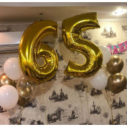Композиция с двумя букетами из бело-золотых шариков в 65 лет